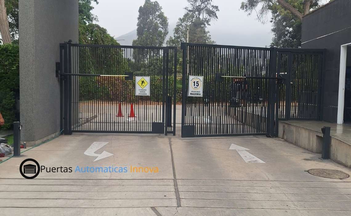 Puerta batiente automática de doble hoja de uso súper intensivo instalada en condominio de La Molina, Lima, por Puertas Automáticas Innova SAC