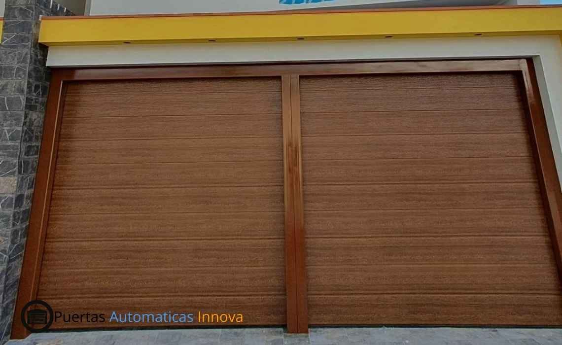 Instalación y automatización de dos puertas seccionales automáticas con paneles importados y control remoto, realizada por Puertas Automáticas Innova SAC