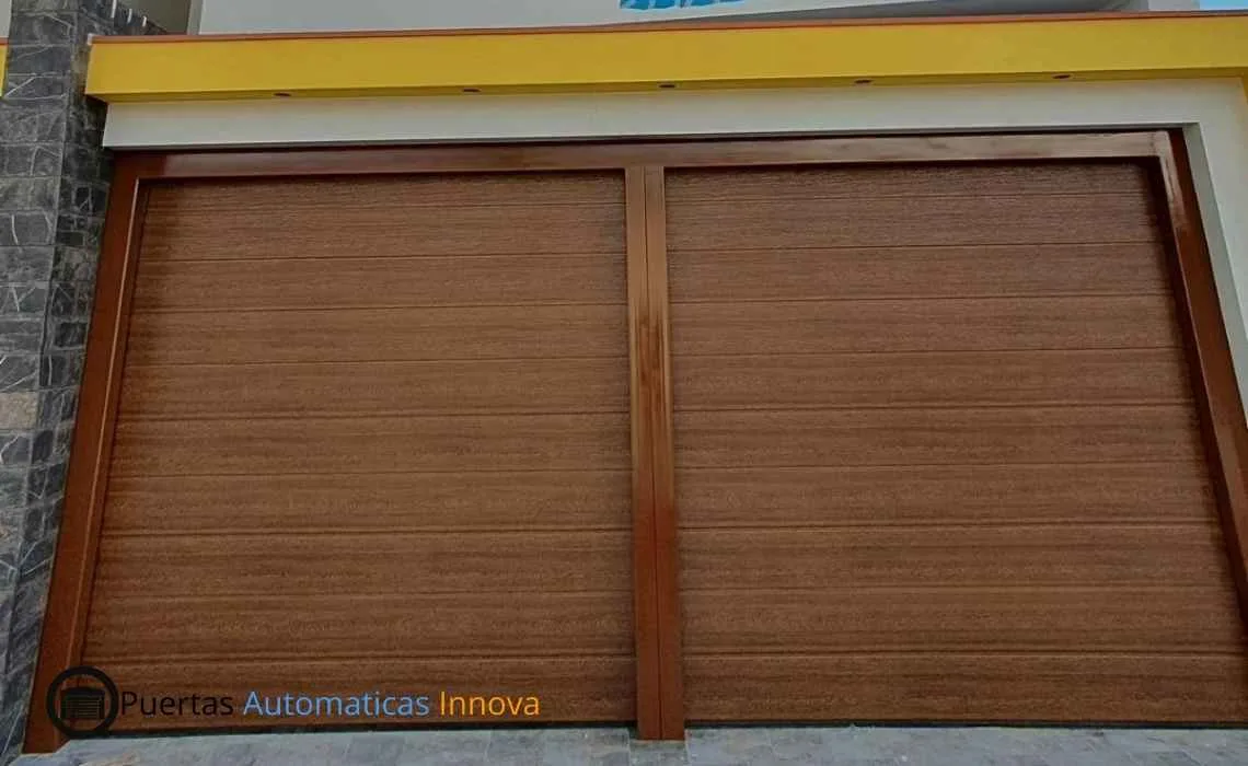 Instalación y automatización de dos puertas seccionales automáticas con paneles importados y control remoto, realizada por Puertas Automáticas Innova SAC