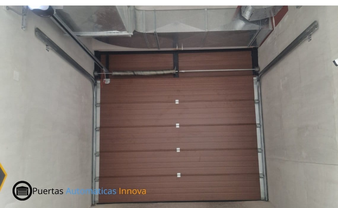 Puerta seccional automática con paneles importados y motor SmartLift de uso intensivo, instalada por Puertas Automáticas Innova SAC
