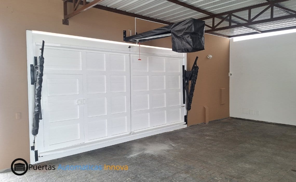 Automatización de puerta levadiza con motor SmartLift y cambio de resortes realizada en Punta Hermosa, Lima, por Puertas Automáticas Innova SAC